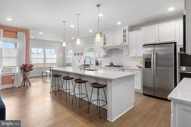 kitchen with white cabinets, light hardwood / wood-style floors, sink, and stainless steel appliances