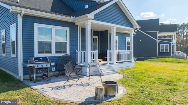 rear view of property featuring a lawn and covered porch