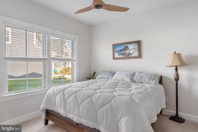 bedroom with multiple windows, ceiling fan, and carpet