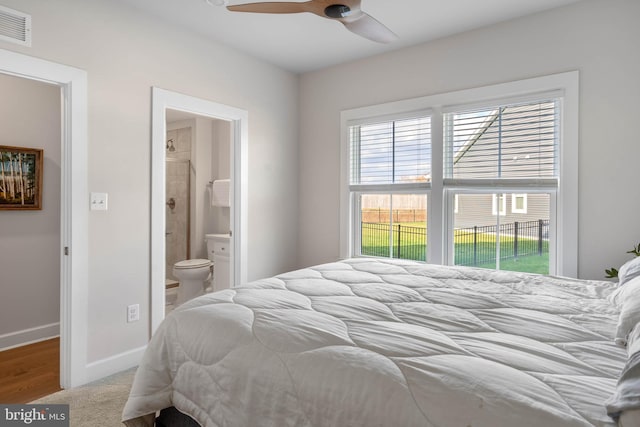 bedroom featuring hardwood / wood-style flooring, ceiling fan, and ensuite bath