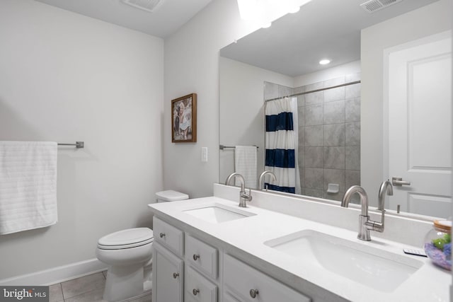 bathroom featuring tile patterned flooring, vanity, toilet, and walk in shower