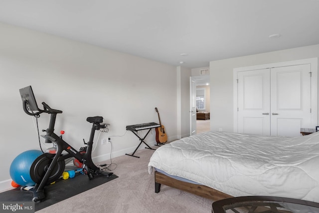 bedroom with light colored carpet and a closet