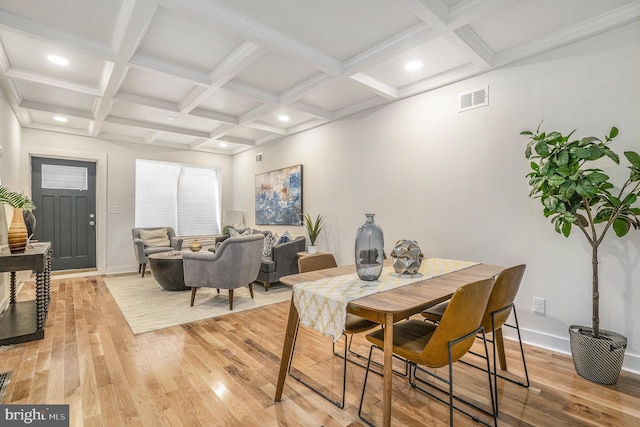 dining area featuring beam ceiling, light hardwood / wood-style floors, and coffered ceiling