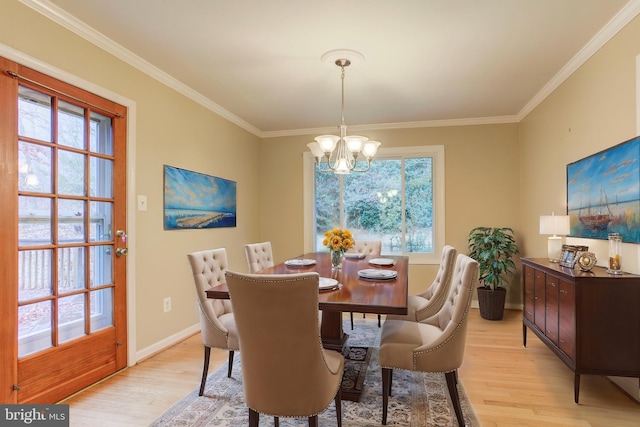 dining space featuring ornamental molding, light hardwood / wood-style floors, plenty of natural light, and a notable chandelier