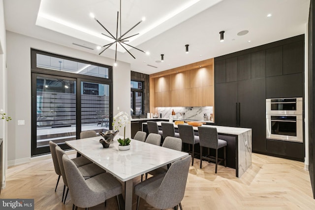 dining room featuring a notable chandelier and light parquet floors