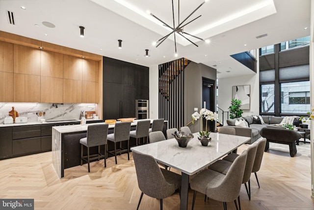 dining room with a notable chandelier and light parquet flooring