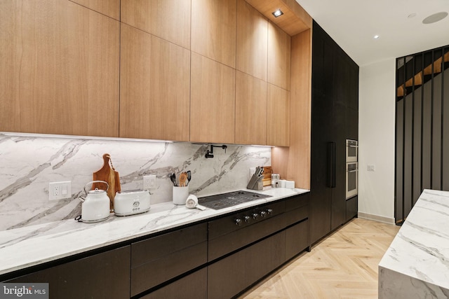 kitchen featuring decorative backsplash, light stone counters, oven, and light parquet flooring