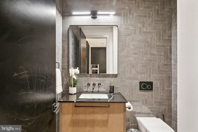 bathroom featuring vanity, toilet, and tasteful backsplash