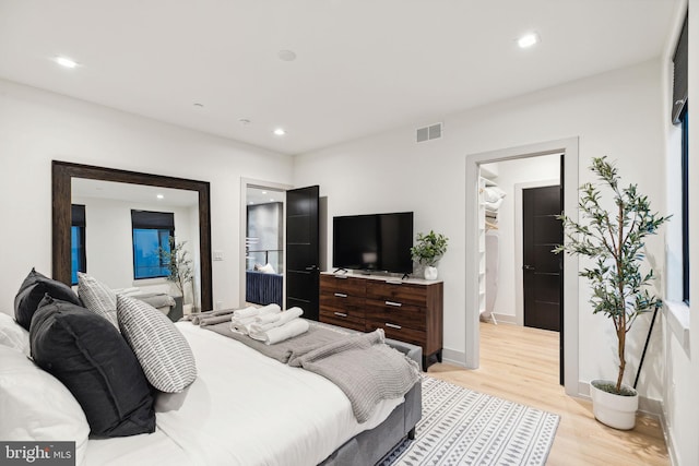 bedroom featuring ensuite bath and light hardwood / wood-style flooring