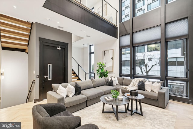 living room with light parquet floors and a high ceiling