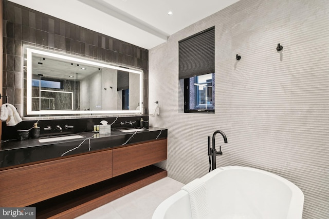 bathroom featuring vanity, tile patterned floors, tile walls, and a tub