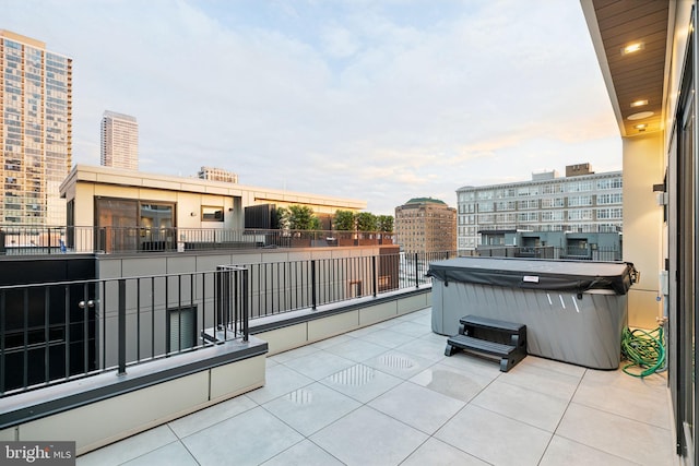 view of patio featuring a balcony and a hot tub