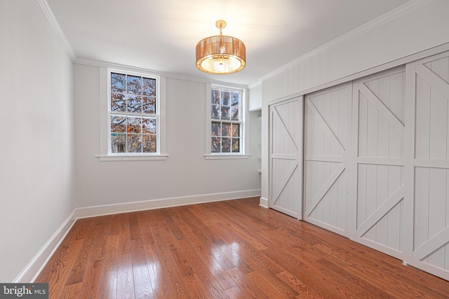 unfurnished bedroom with crown molding and wood-type flooring