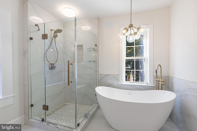 bathroom with shower with separate bathtub and an inviting chandelier