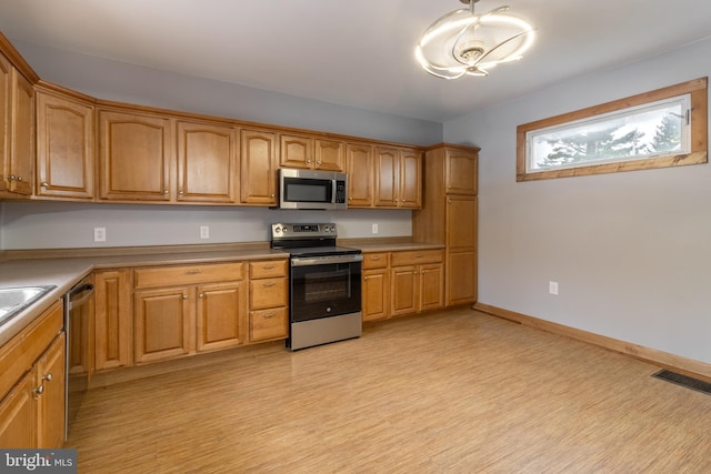 kitchen with light hardwood / wood-style floors and appliances with stainless steel finishes