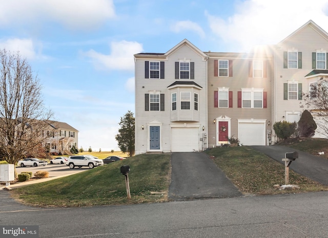 multi unit property featuring a front lawn and a garage