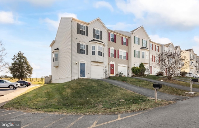 townhome / multi-family property with a garage and a front lawn