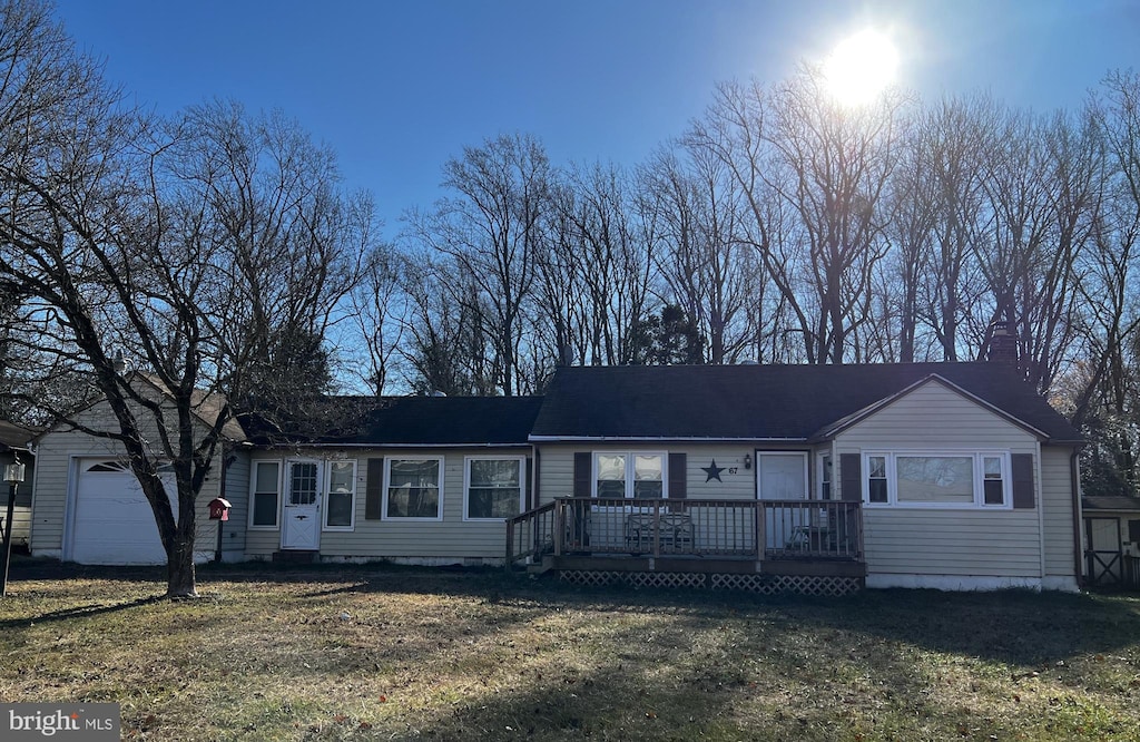 single story home with a front yard, a garage, and a deck