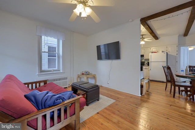 living room with beam ceiling, radiator, ceiling fan, and light wood-type flooring