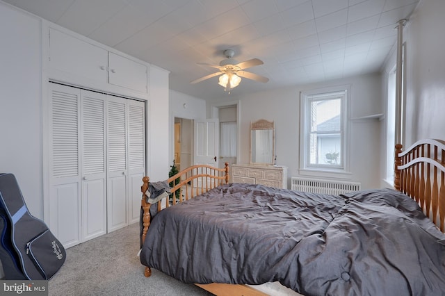 carpeted bedroom with radiator, a closet, and ceiling fan