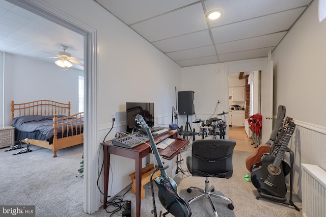 office with a paneled ceiling, ceiling fan, and carpet