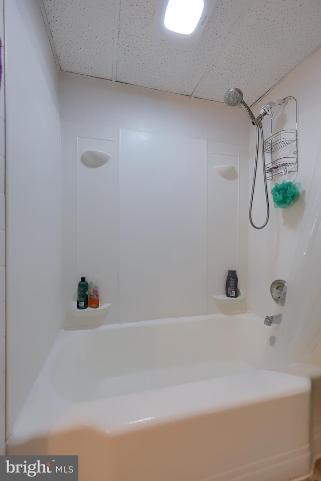 bathroom featuring a paneled ceiling and shower / bathtub combination