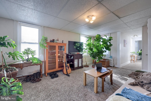 living room featuring carpet flooring and a paneled ceiling