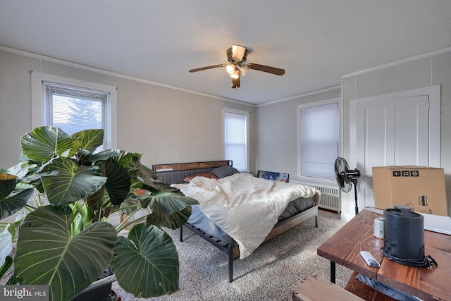 carpeted bedroom with radiator, ceiling fan, and ornamental molding