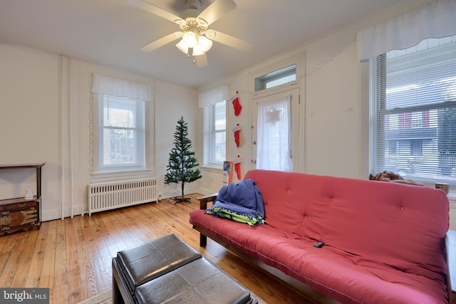 living room with hardwood / wood-style floors, radiator, and ceiling fan