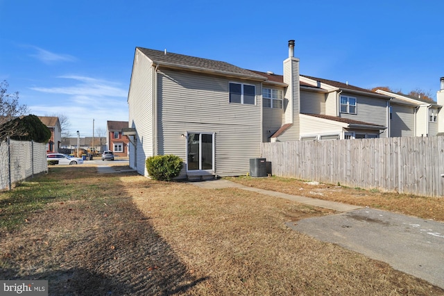 back of property featuring a yard and central air condition unit