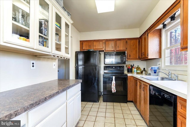 kitchen featuring black appliances, light tile patterned flooring, white cabinetry, and sink