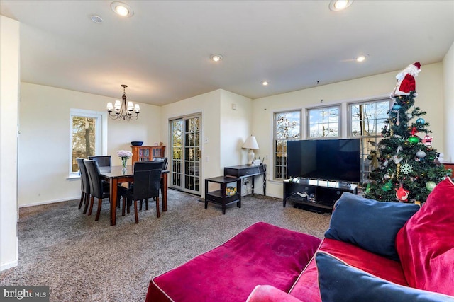 living room featuring carpet flooring and an inviting chandelier