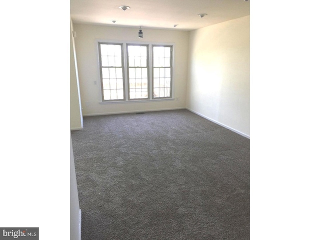 empty room featuring dark colored carpet