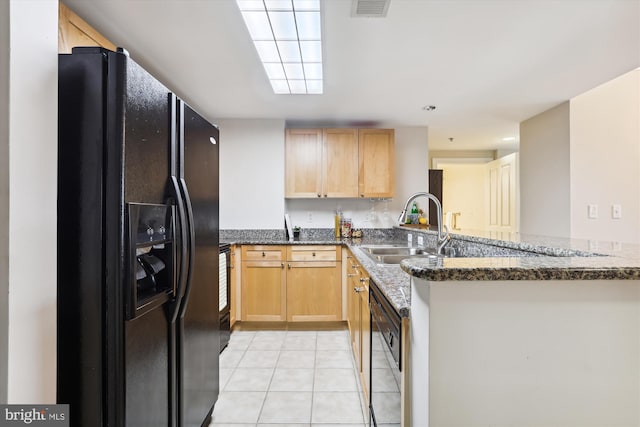 kitchen featuring black appliances, sink, dark stone countertops, light tile patterned flooring, and kitchen peninsula