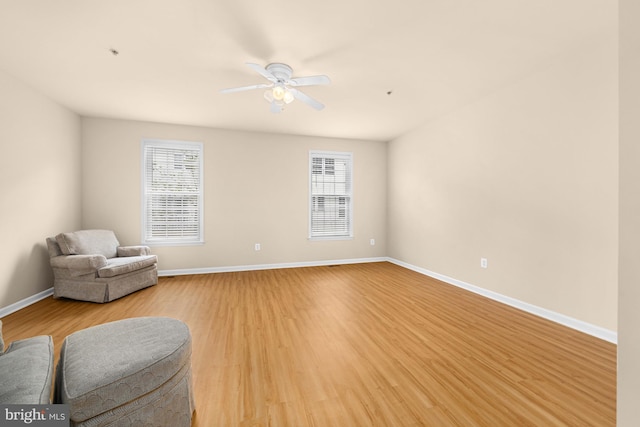 living area with hardwood / wood-style flooring and ceiling fan