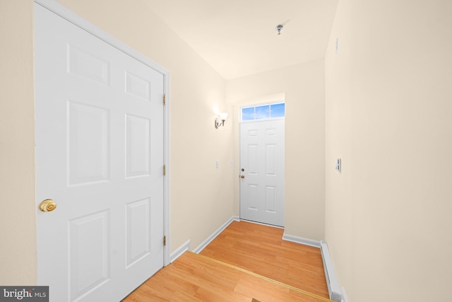 doorway featuring baseboard heating and hardwood / wood-style floors