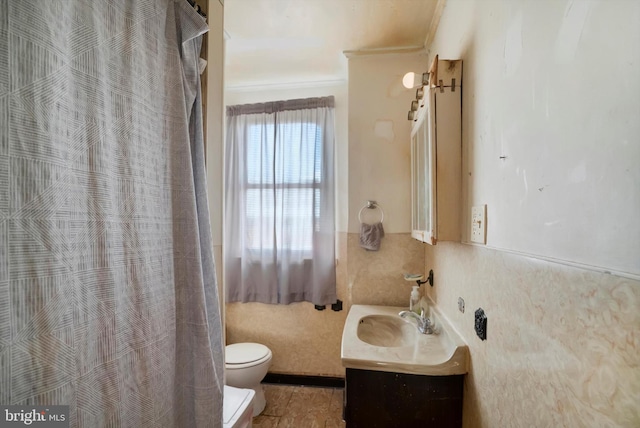 bathroom with toilet, vanity, and ornamental molding