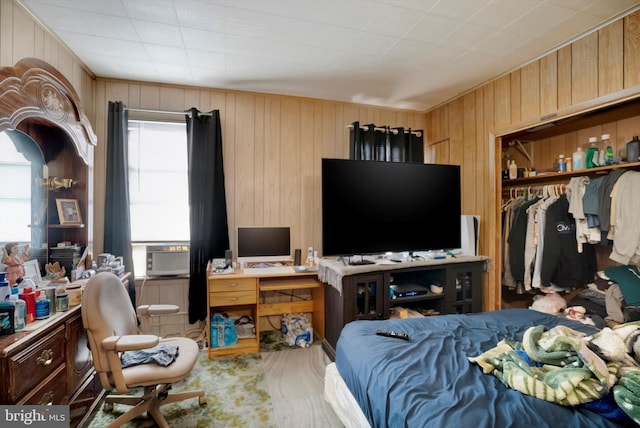 bedroom with a closet, cooling unit, and wood walls