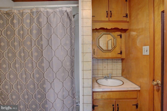 bathroom featuring decorative backsplash, vanity, and a shower with shower curtain