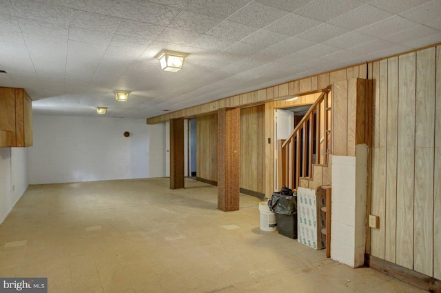 basement featuring wood walls