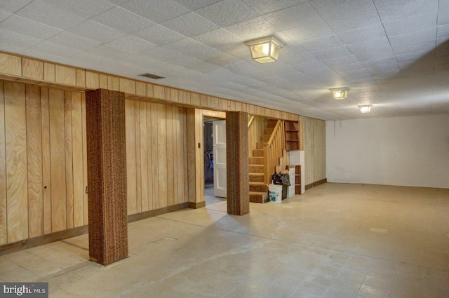 basement featuring wooden walls