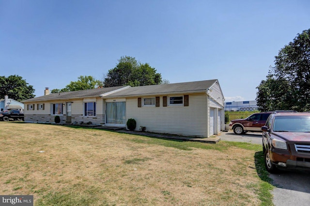 ranch-style house featuring a front yard and a garage