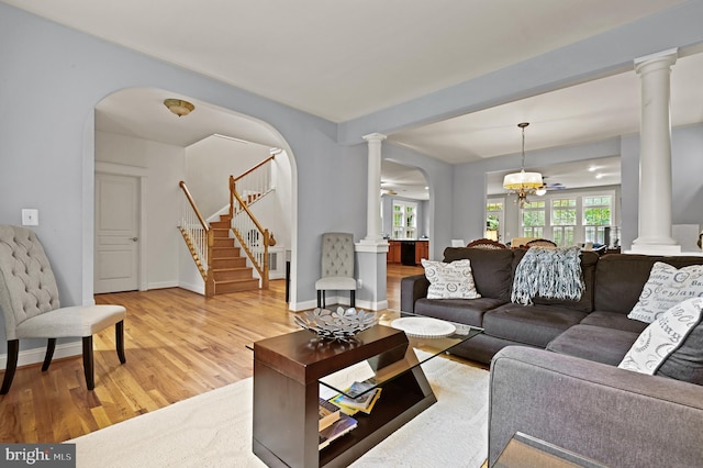 living room featuring hardwood / wood-style flooring and ceiling fan with notable chandelier