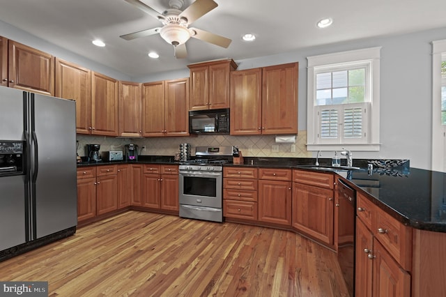 kitchen with ceiling fan, sink, light hardwood / wood-style floors, decorative backsplash, and black appliances