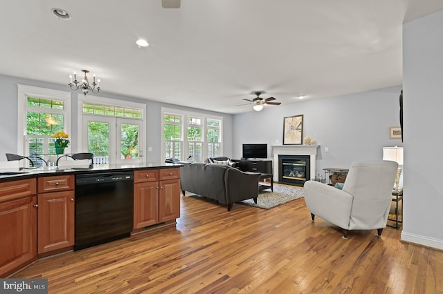 kitchen featuring light hardwood / wood-style floors, ceiling fan with notable chandelier, and black dishwasher