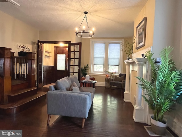 sitting room featuring a chandelier, dark wood-type flooring, and a textured ceiling