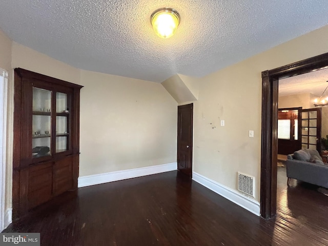 interior space with dark hardwood / wood-style flooring, a textured ceiling, and a chandelier