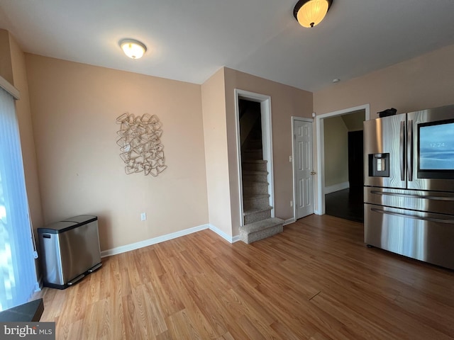 kitchen featuring stainless steel fridge and light hardwood / wood-style floors