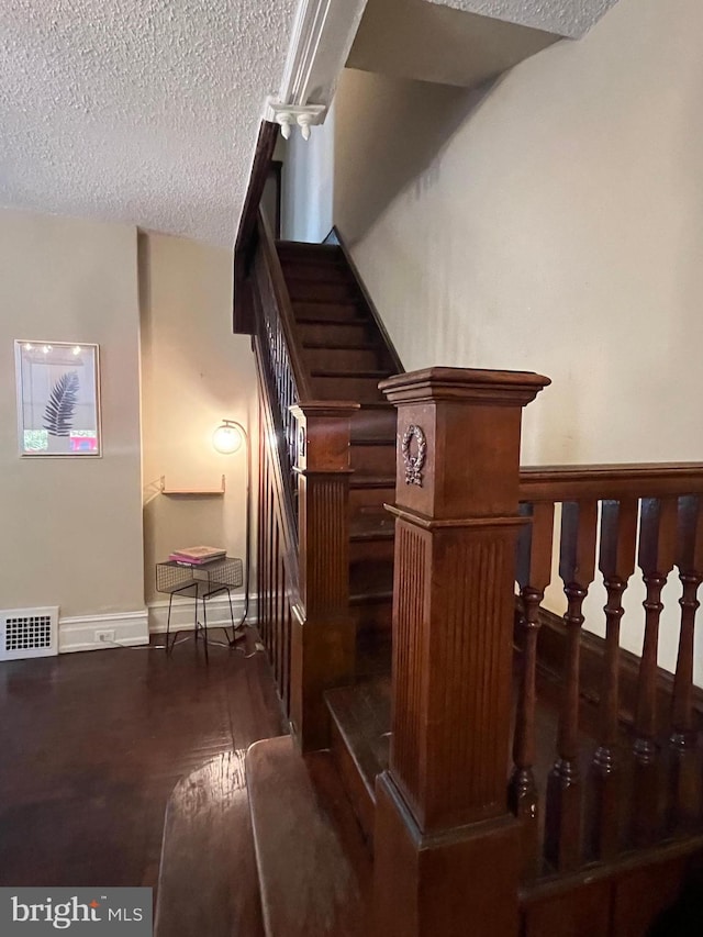 staircase with a textured ceiling