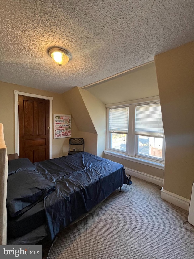 carpeted bedroom with a textured ceiling and lofted ceiling